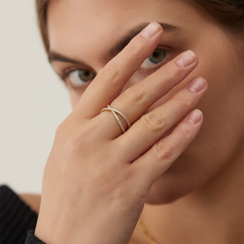 Close-up of a woman's hand wearing a gold ring with a blurred background