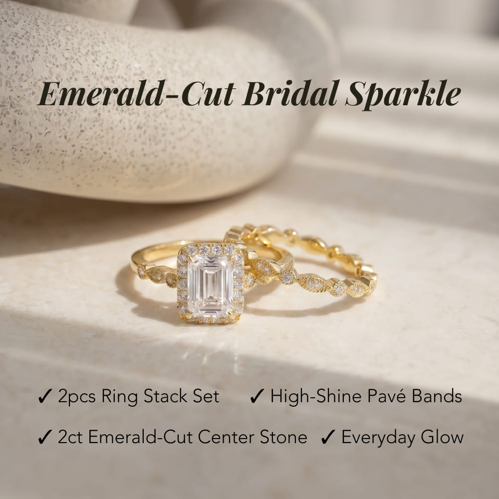 Gold ring stack set with emerald-cut center stone on a neutral background