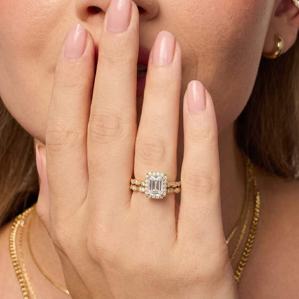 Close-up of a hand wearing a diamond ring with a blurred background