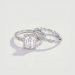 Diamond ring with a rectangular center stone on a light gray background