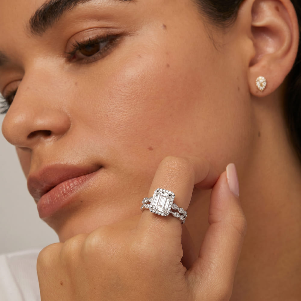 Close-up of a woman wearing a diamond ring and earrings.