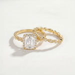 Gold ring with a large diamond and a smaller diamond-studded band on a light background