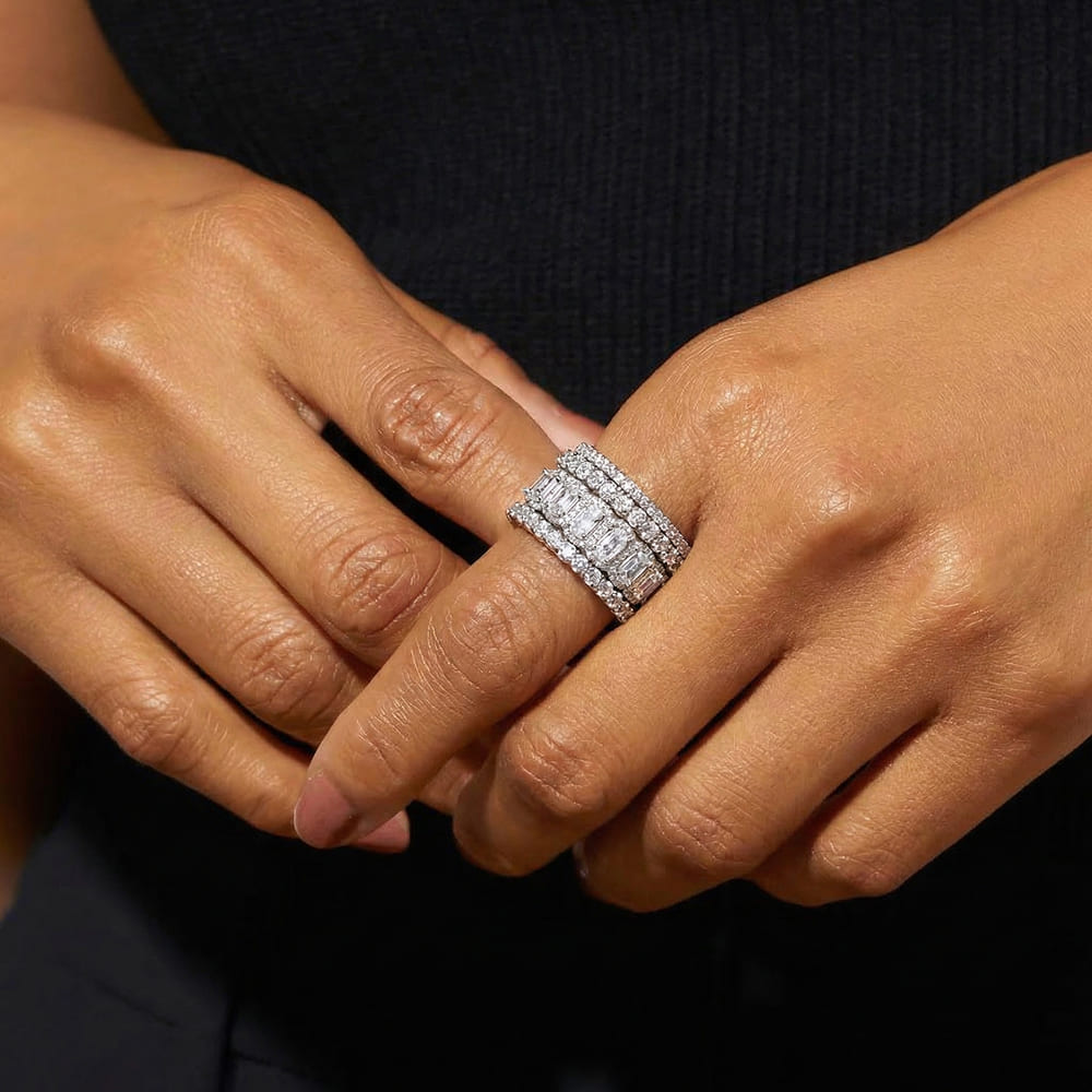 Close-up of a hand wearing a diamond ring with a dark background