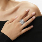 Hand wearing a diamond ring on a neutral background