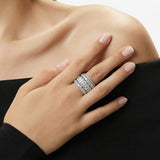 Hand wearing a diamond ring on a neutral background