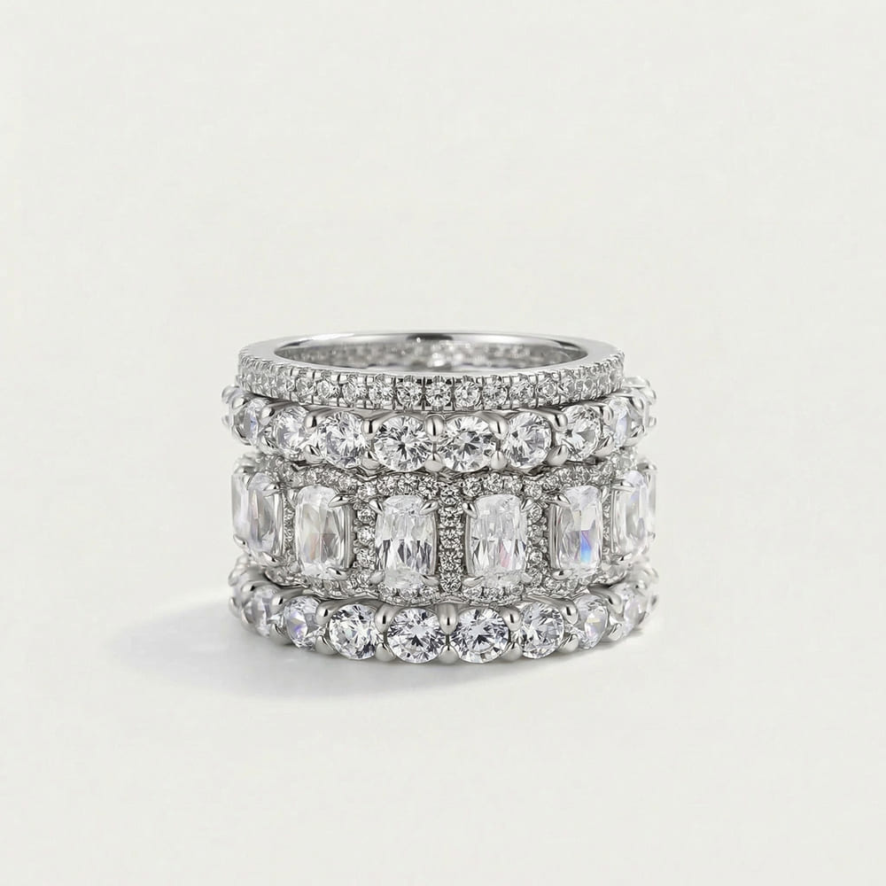 Stack of silver rings with gemstones on a light gray background