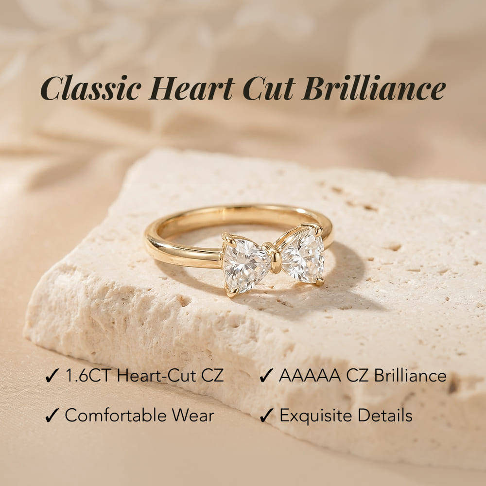 Gold ring with heart-cut gemstones on a beige stone, with text highlighting features.