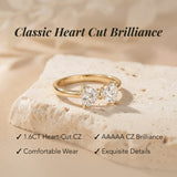 Gold ring with heart-cut gemstones on a beige stone, with text highlighting features.