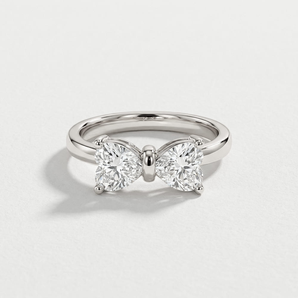 Silver butterfly-shaped ring with diamonds on a light gray background