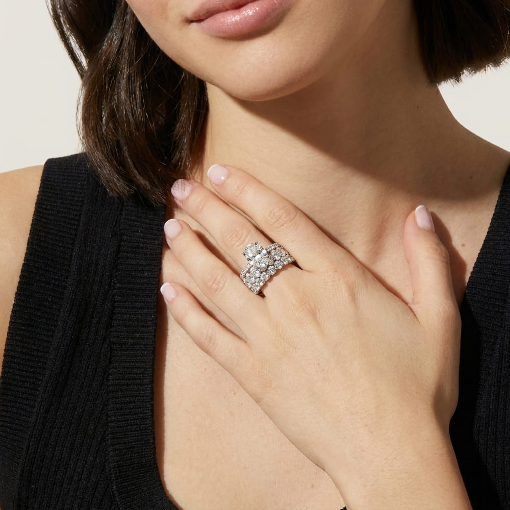 Close-up of a woman wearing a sparkling diamond ring on her hand.