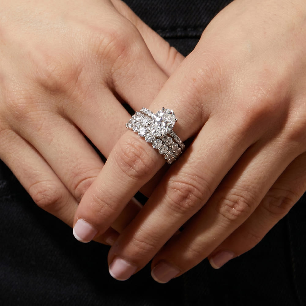 Close-up of a hand wearing a diamond ring on fingers.